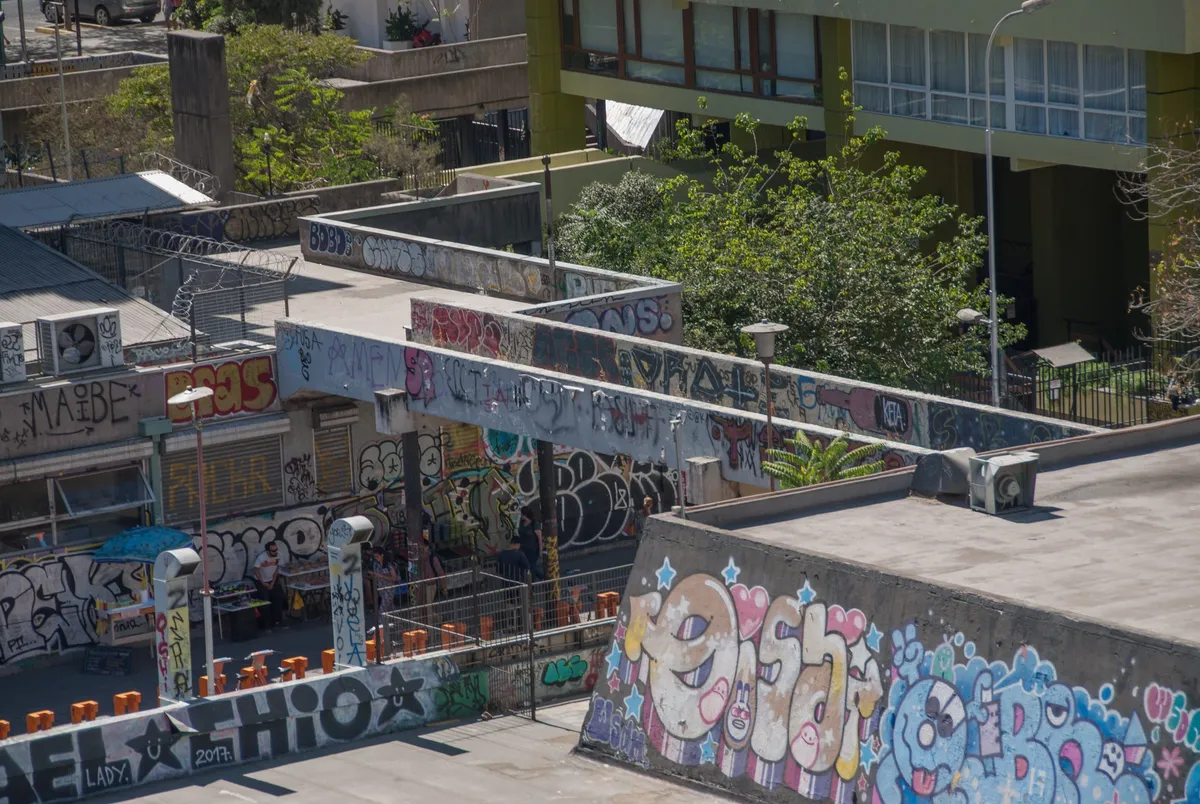 Plataformas peatonales de la Remodelación San Borja, con muros cubiertos de grafitis y árboles entre los edificios.